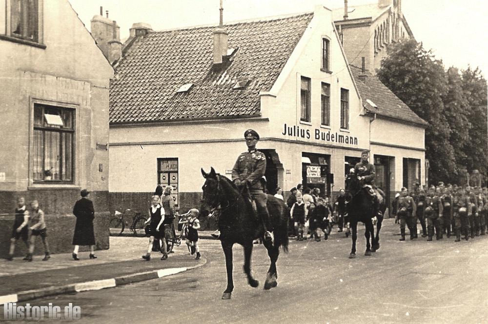 Einzug in Bremen - Die Kompanie marschiert durch die Kornstr. im Hintergrund das Geschäft von Julius Budelmann, Kornstr. 33/35, Ecke Hermannstr.